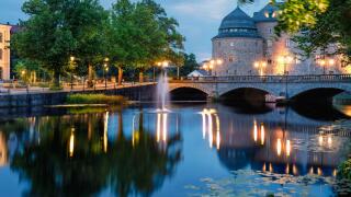 Illuminated Orebro Castle and stone bridge in blue hour . Tourist atraction and history entusiast destination. Orebro, Sweden. Copy space