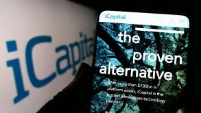 Person holding cellphone with website of Institutional Capital Network Inc. (iCapital) on screen with logo. Focus on center of phone display.