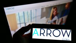 Person holding smartphone with logo of British investment company Arrow Global Group Plc on screen in front of website. Focus on phone display.