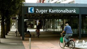 People cycle in front of the headquarters of Zuger Kantonalbank bank in Zug, Switzerland August 30, 2016.  REUTERS/Arnd Wiegmann