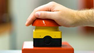 Hand pressing red buzzer