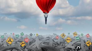 Easy way forward rise above confusion leadership concept with a businessman in a balloon flying and soaring over a complicated group of roads as a business metaphor of innovative creative thinking for success.