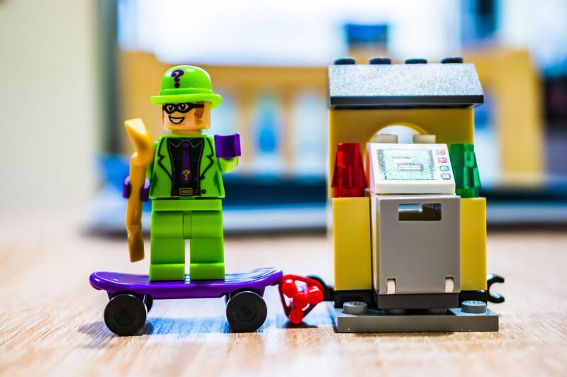 POZNAN, POLAND - Feb 29, 2020: Lego The Riddler villain figure standing on a skateboard being busy with a robbery in soft focus background. Figurine i