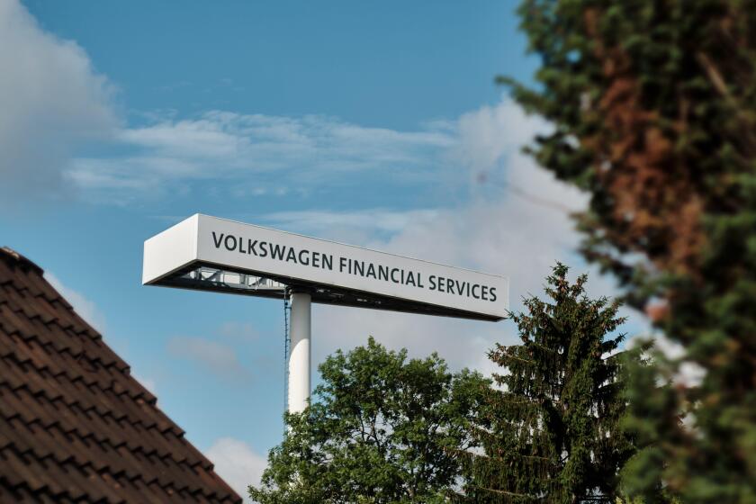 Brunswick, Germany. 22nd June, 2021. A pylon with the inscription "Volkswagen Financial Services" rises up behind the roof of a residential building. Credit: Stefan Jaitner/dpa/Alamy Live News