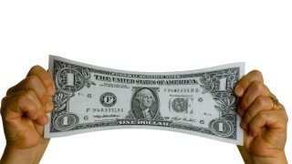 dollar bill USA stretched between two hands. Image shot 2007. Exact date unknown.