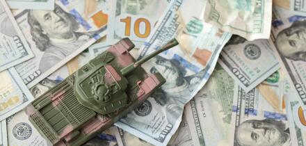 Tank on crumpled hundred dollar bills banknotes. Background of war funding and military support price for United States of America. Tank on crumpled