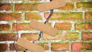 Renovation of an old cracked brick wall - concept image with bandaid patch