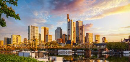 Golden sunrise view of the skyline of Frankfurt am Main, Germany, with banking skyscrapers, Eiserner Steg Bridge and River