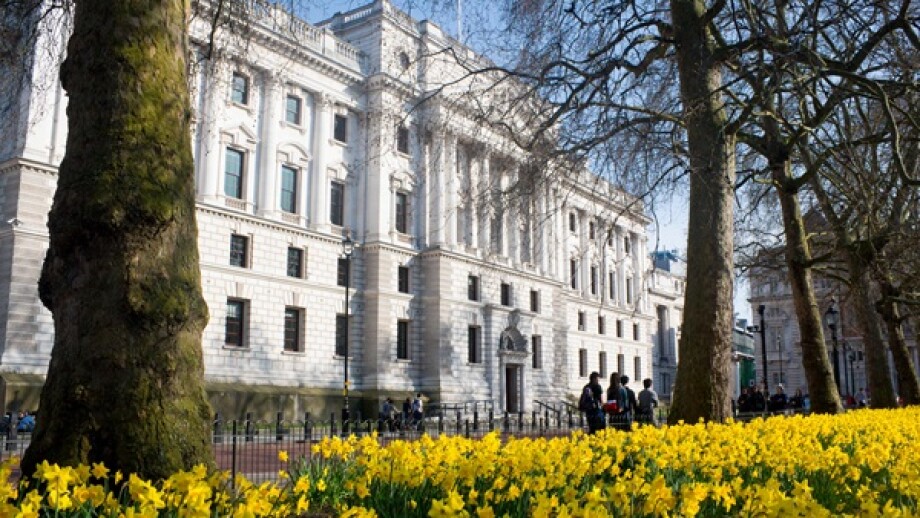 HM Treasury building with daffodils in St James's Park in foreground in spring springtime Westminster London England UK