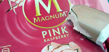 A Magnum Ice cream lolly with a bite out of it, in pink raspberry flavour.
