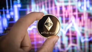 Ethereum cryptocurrency, physical coin in front of colorful char