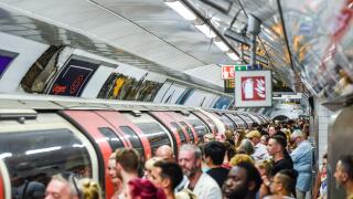 Crowded London Underground station platform and train, Tottenham Court Road tube station busy with passengers at peak time. Packed