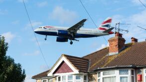 A low flying British Airways plane coming in to land above Myrtle Avenue at Heathrow airport, London, UK