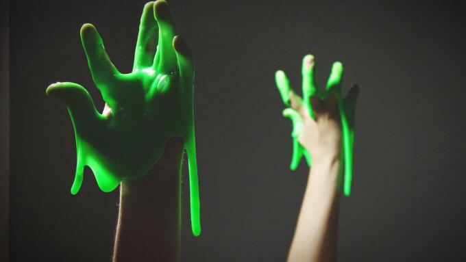 Cropped Hand With Green Slime Against Black Background