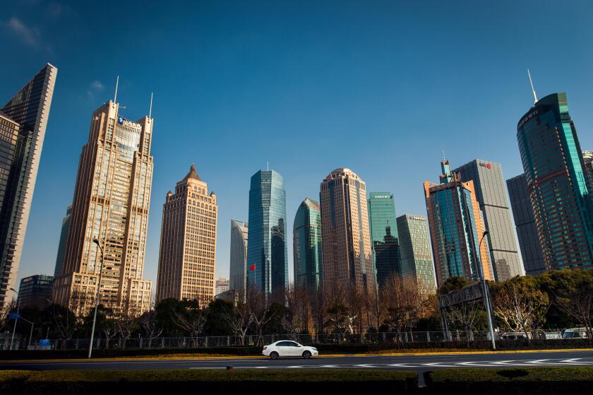 white car in front of Shanghai skyscrapers under blue sky