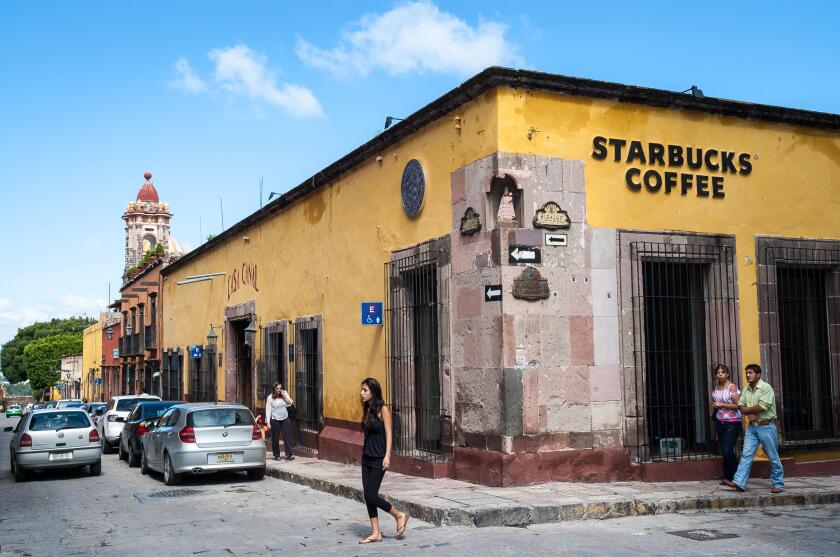 Mexico San Miguel de Allende Starbucks store in an old building on the corner of a cobblestone street in this picturesque town. Exterior view.