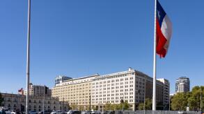 Huge Chilean flag in front of the La Moneda Palace, left, and the Banco Estado building in downtown Santiago, Chile.