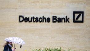 Deutsche Bank London - a woman walk past the London offices of Deutsche Bank in the Square Mile, London's Financial District.