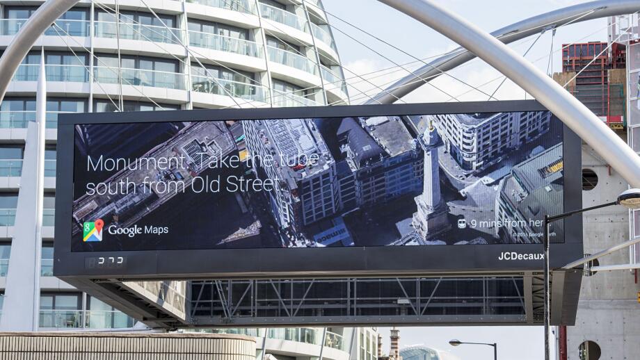Digital Google Maps billboard at Old Street London displaying Monument Tube directions