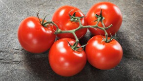 Fresh ripe tomatoes on stone background