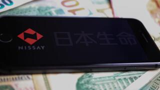 Viersen, Germany - March 1. 2021: Closeup of smartphone with logo lettering of nippon life insurance company on paper money currency