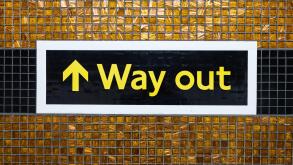Directional Way Out arrow sign on public transport station interior