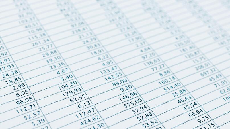 Business data report selective focus close up. Monthly stock stats spreadsheet. Blue toned.