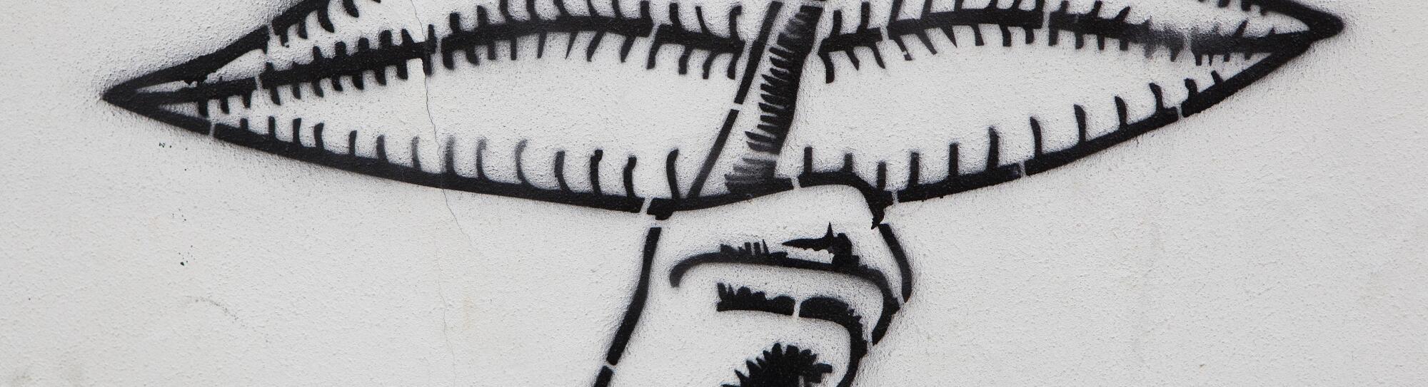 Graffito with closed mouth and a finger calling for silence