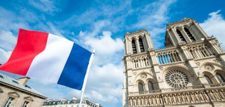 French flag flying in front of Notre Dame Cathedral in Paris, France