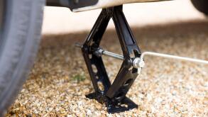 Close up of a car jack underneath a car. Part of a series of photos depicting changing a flat tyre (tire)