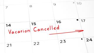 Vacation cancelled written in red marker on a calendar.