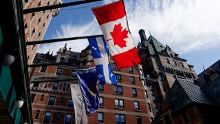 Quebec Flag (Fleur de Lys) and the Canadian flag (Maple Leaf) flying outside the Chateau Frontenac Hotel in Quebec City, Canada