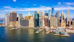Aerial view of the New York City Financial District (FiDi) skyline taken from across the East River in Brooklyn Bridge Park
