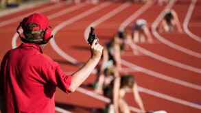 Race official holding a starting gun at the beginning of a track event