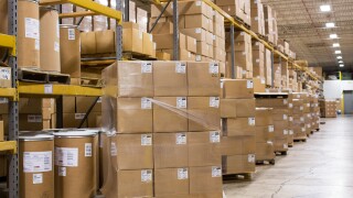 An industrial warehouse full of cardboard boxes on shelving. 