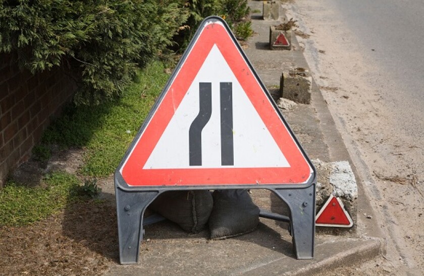 Red triangular sign warning of road narrowing ahead, UK