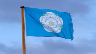 The Yorkshire white rose on a Yorkshire flag blowing in the wind