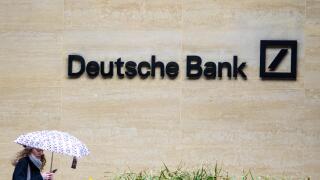 Deutsche Bank London - a woman walk past the London offices of Deutsche Bank in the Square Mile, London's Financial District.