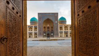 Poi Kalon Madrassa through the carved wooden doors in Bukhara, Uzbekistan.
